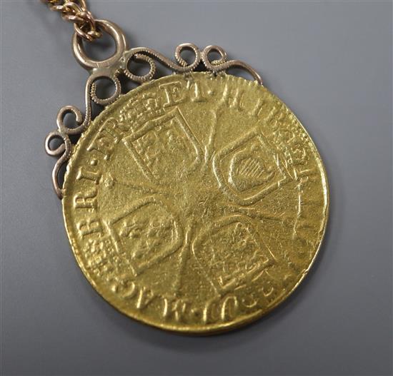 A Queen Anne 1711 gold guinea (worn), now with yellow metal pendant mount, on a 9ct chain.